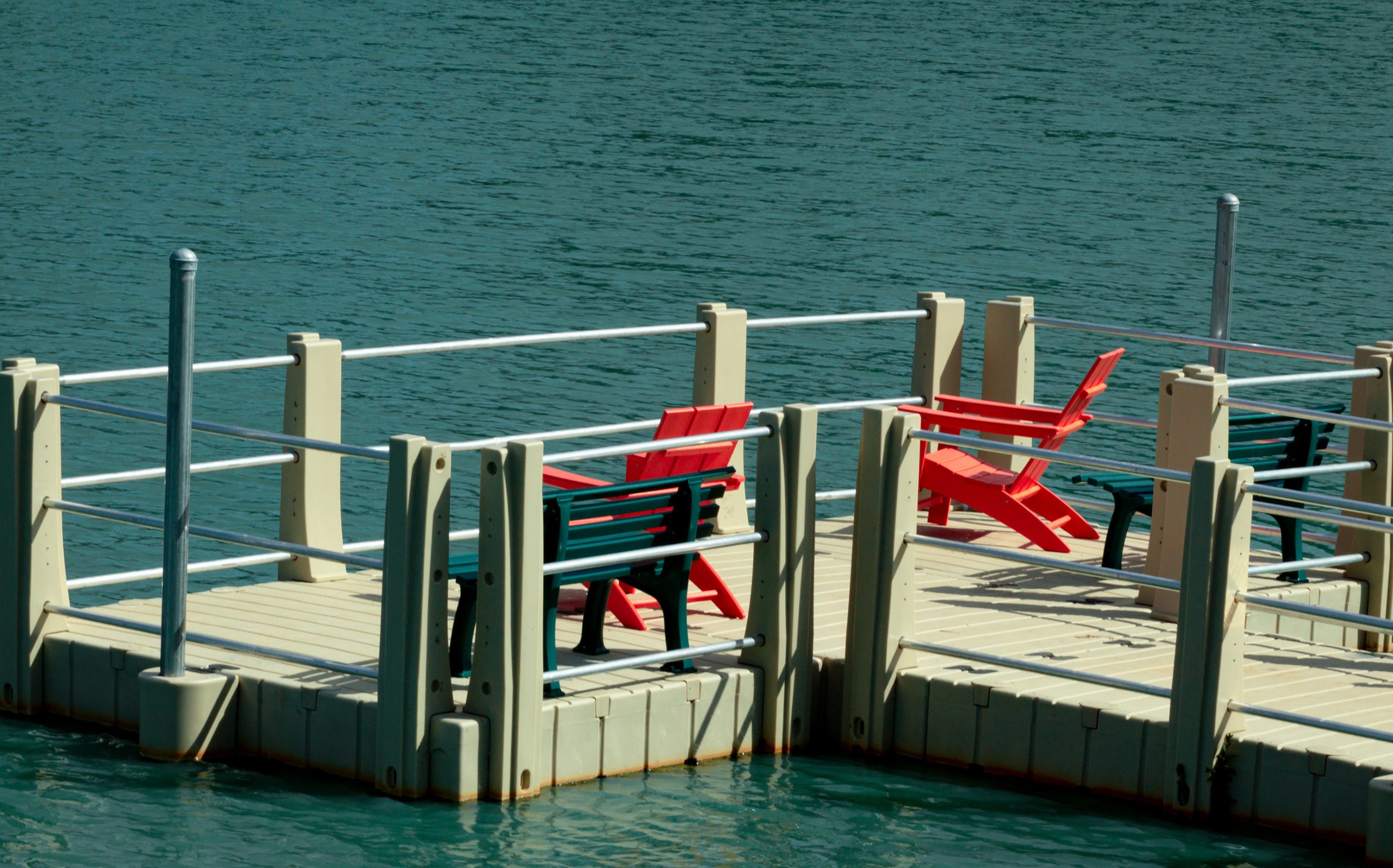 2 red chairs on a dock overlooking the lake in Conroe--many of the best things to do in Conroe tx revolve around the lake!