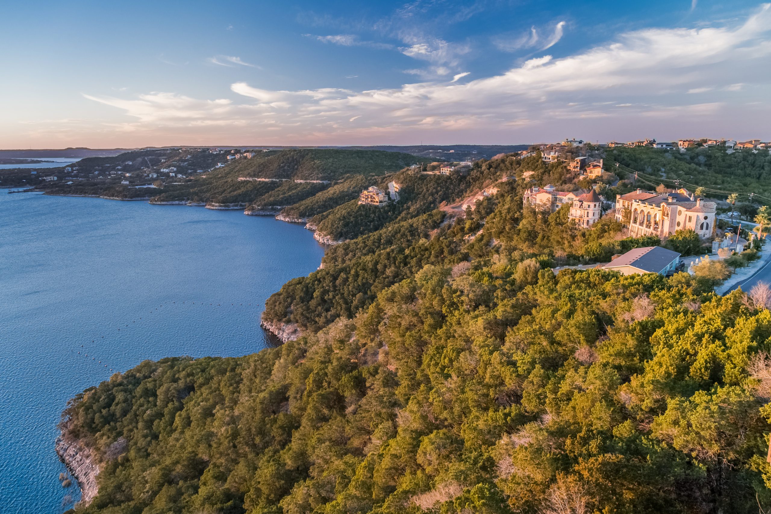 View of Lake Travis Austin Texas from above with green cliffs on the right and blue water on the left