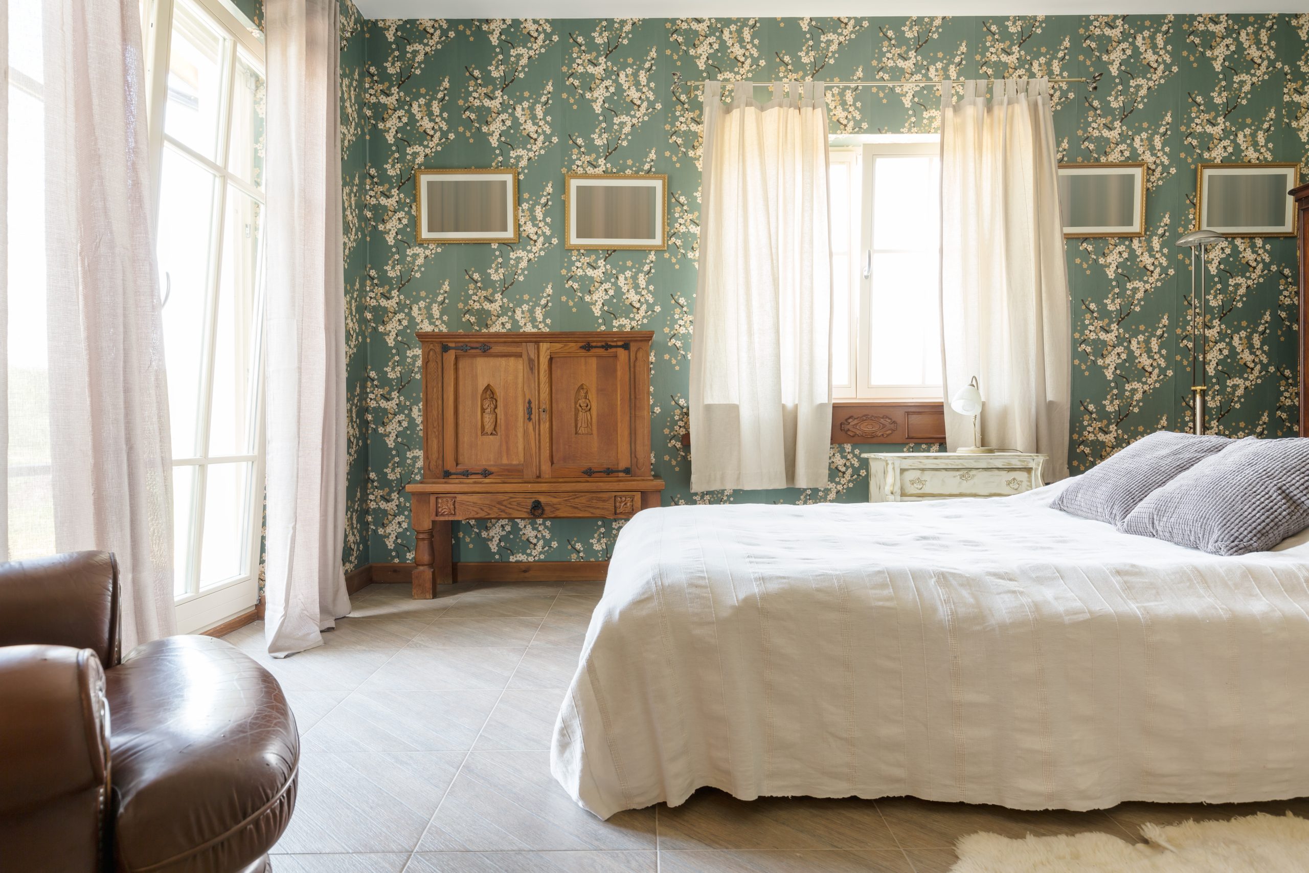 bedroom in a historic inn with teal wallpaper and white linens. historic bed and breakfasts in fredericksburg tx are among the best places to stay