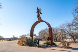 Kate Storm standing underneath the world's largest spur in lampasas tx, a texas roadside attraction