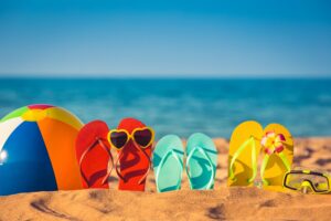 collection of coloful flipflops on a beach, reminiscent of summer in texas activities