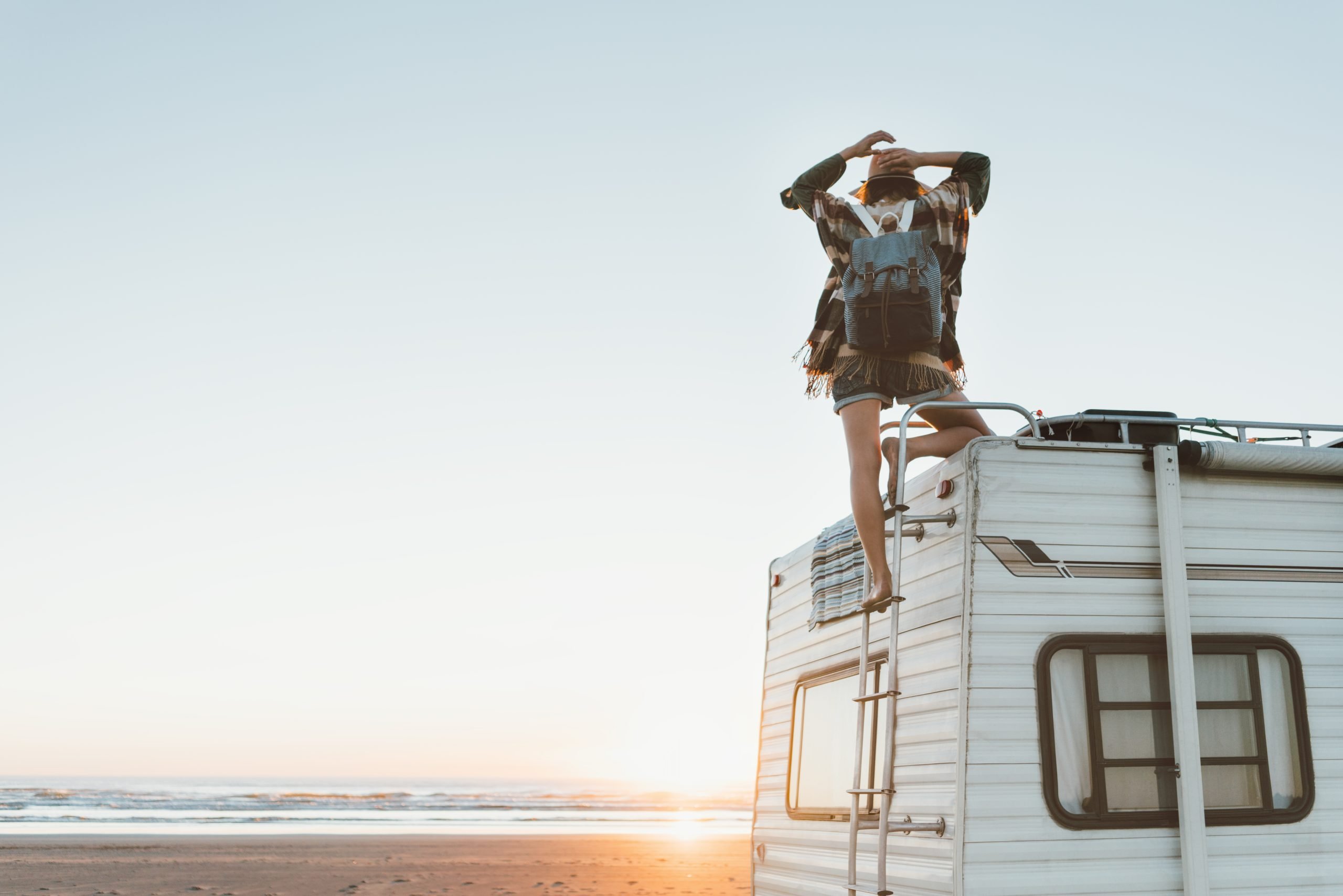 woman standing on top of an rv overlooking the beach headed to best texas gulf coast rv parks